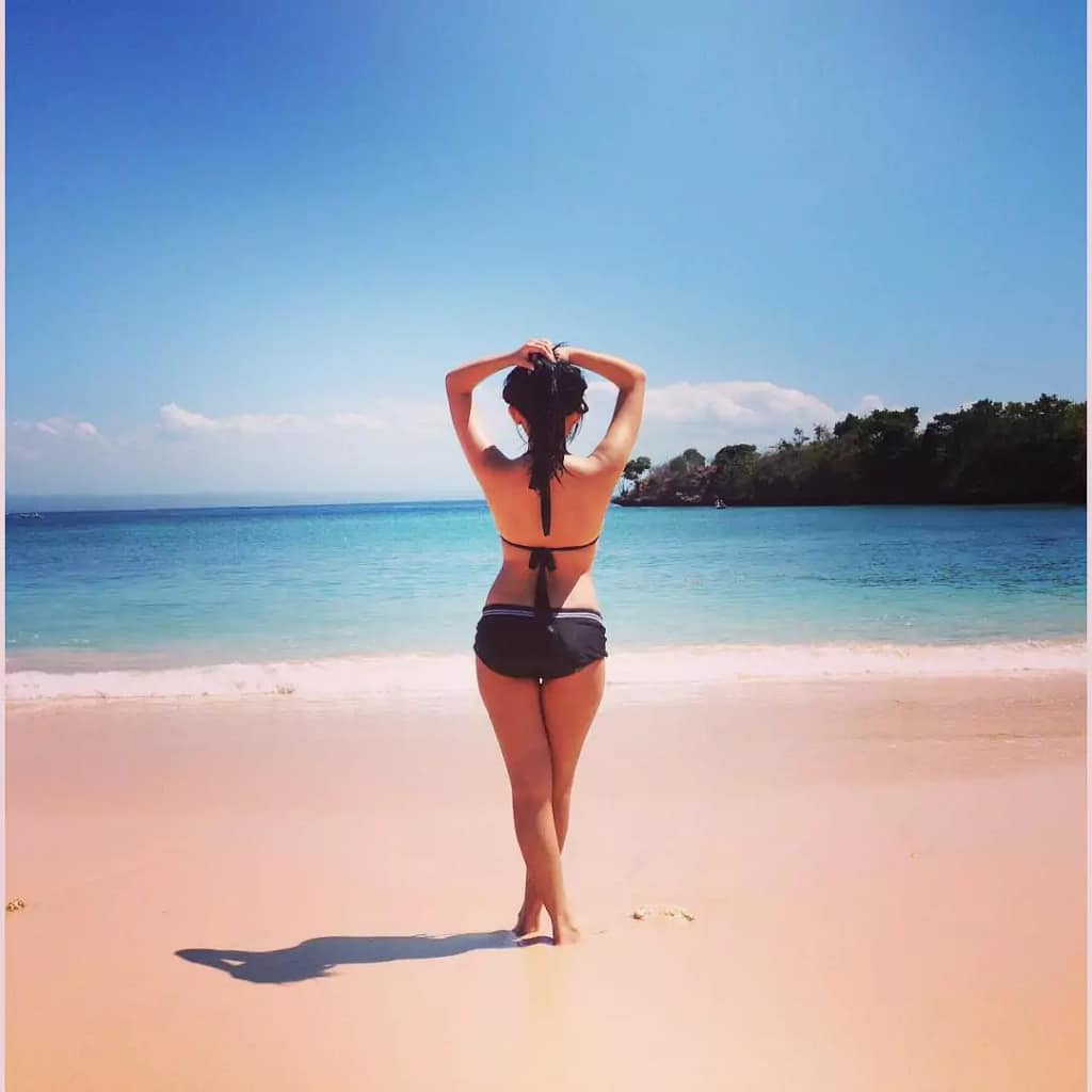 local woman pose at pink sand beach Lombok 