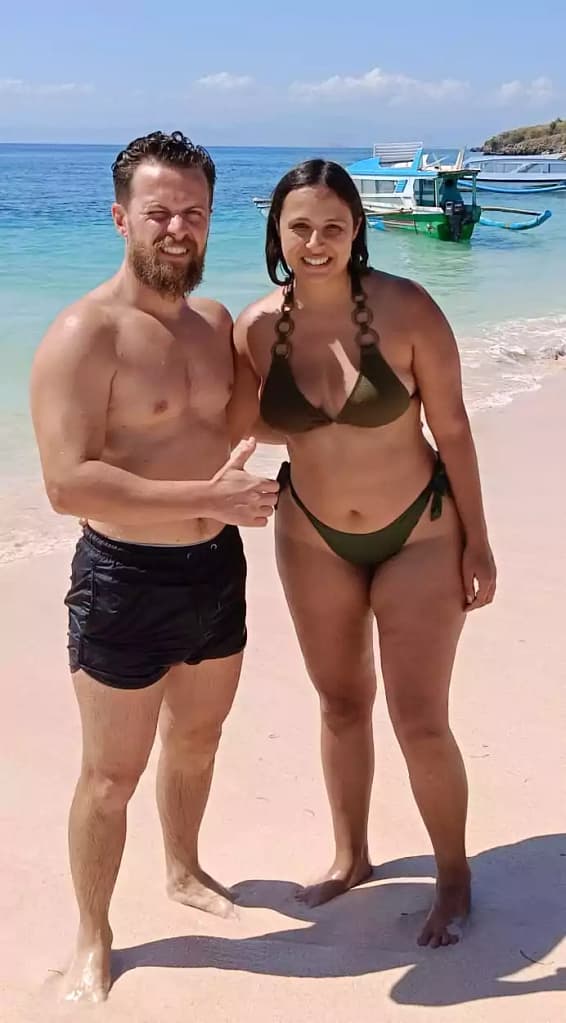 A couple of Hey Bali guest travelers look happy taking pictures on Lombok beach