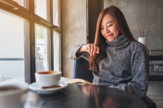 Asian woman relaxing and reading a book with a latte or cappuccino cup on a table next to a window in a modern cafe - The Best Coffee Shop Opens Early in Pecatu