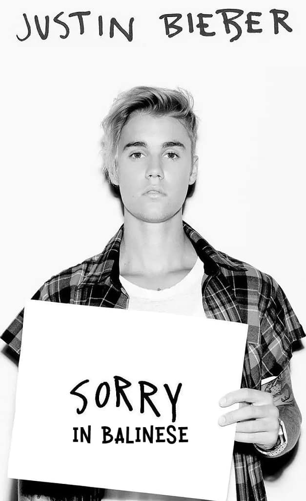 Photo of justin bieber holding a paper and saying sorry in balinese