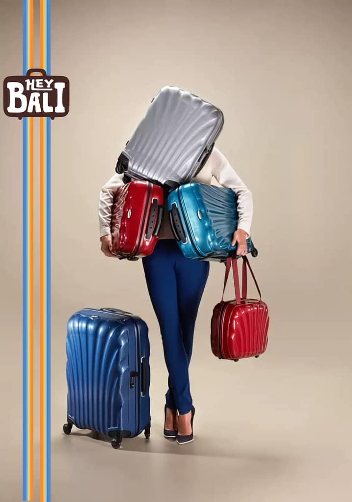 Overloaded traveler carrying too many suitcases, promoting Hey Bali Luggage Storage service