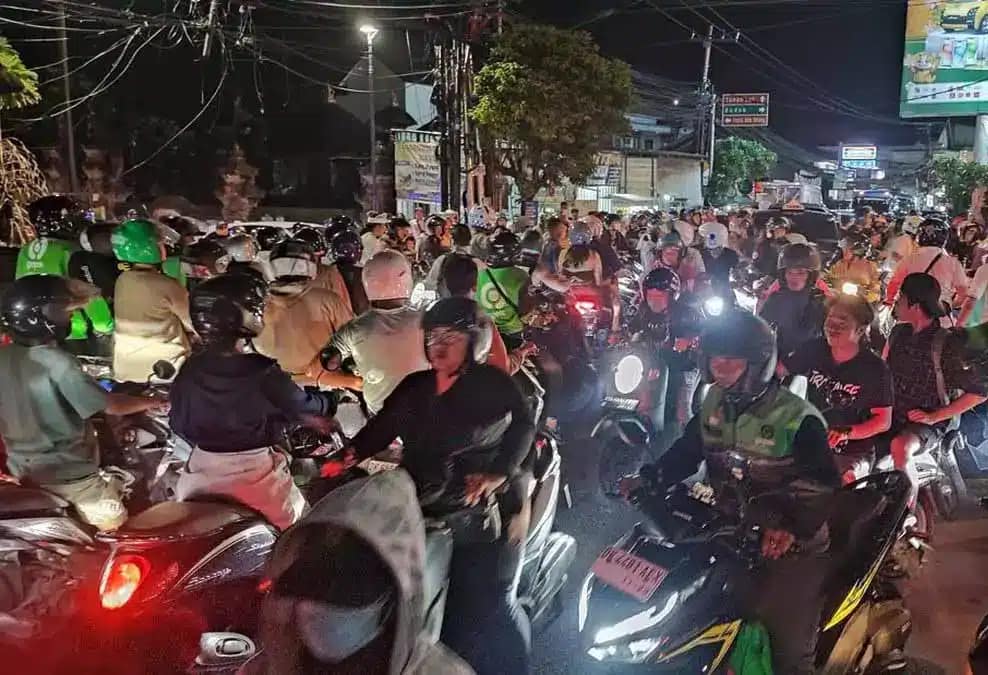 Gridlocked scooters in heavy Bali traffic during rain - worst conditions for motorbike rental