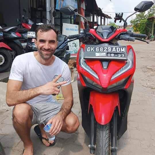 Staff and tourist holding rental contract for motorbike in Bali - successful negotiation for cheap scooter hire - Trusted Bali scooter rental shop in Ubud - Verified by HeyBali 2025