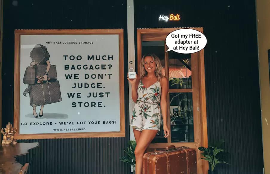 Promotional image for Hey Bali, featuring a cheerful female traveler with her suitcase, showcasing her Free Bali adapter. This image highlights practical solutions for travelers' power needs in Bali.