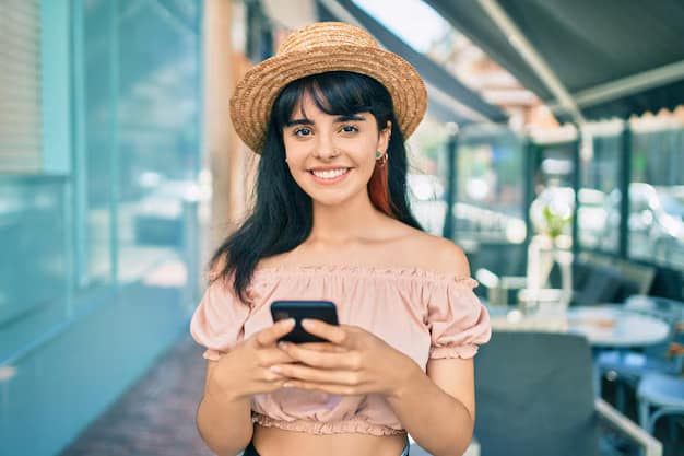 A woman is sitting in a cafe in Bali and holding a cell phone.